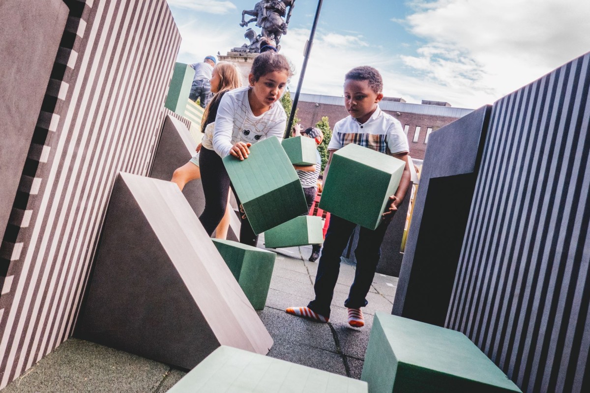 Two children carrying foam blocks from Play Rebellion